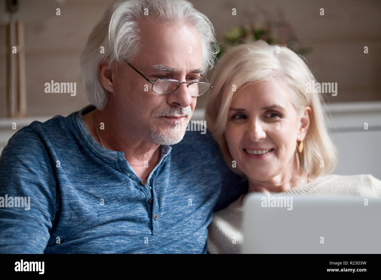Nahaufnahme von Happy älterer Mann und Frau auf Sofa Video at laptop entspannen, lächelnd im Alter von Paar rest verbringt romantische Zeit an mit Comput home Stockfoto