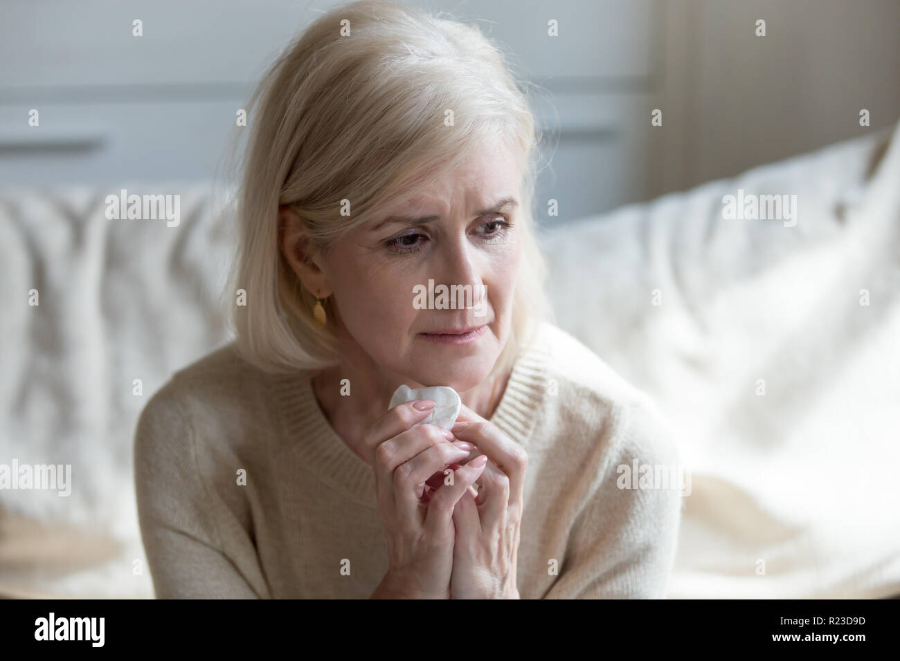 Traurig gealterte Dame weinend Sitzen auf der Couch in Gedanken und Erinnerungen an vergangene Leben Gottes verloren, traurige ältere Frau trauern um verstorben Ehemann fehlt Hi Stockfoto