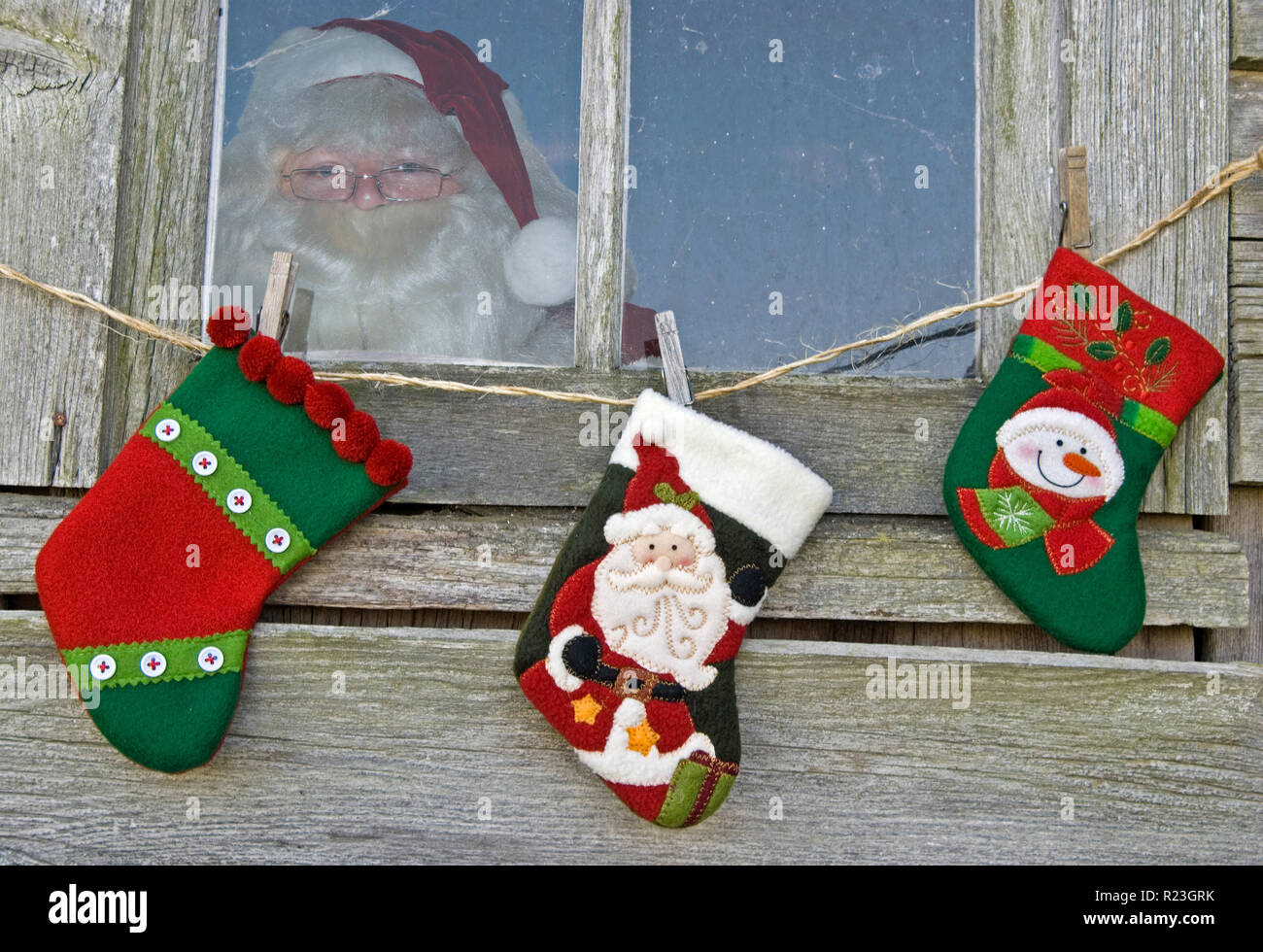 Santa Claus in rustikalen Hütte Fenster mit Urlaub Strümpfe Stockfoto