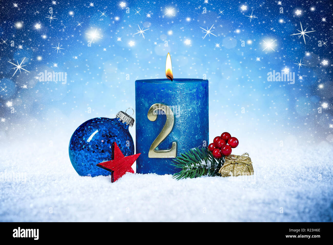Zweiten Adventssonntag blaue Kerze mit goldenen Metall Anzahl rote Dekoration auf Brettern im Schnee vorne Silber panorama bokeh Hintergrund Stockfoto