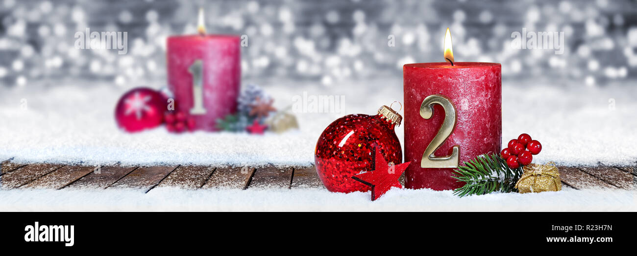 Zweiten Adventssonntag rote Kerze mit goldenen Metall Nummer eins auf Brettern im Schnee vorne Silber panorama bokeh Hintergrund Stockfoto