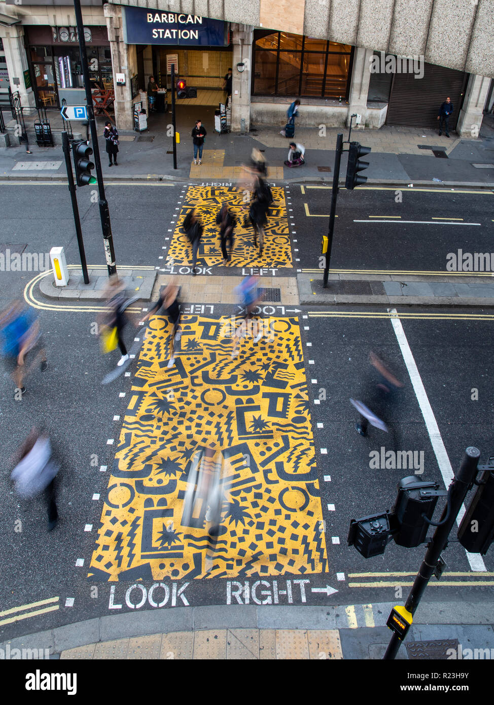 London, England, Großbritannien - 10 September 2018: Fußgänger überqueren einer Hauptstraße in eine Fußgängerzone mit jaunty Mustern bemalt ourside Barbican tube Stati Stockfoto
