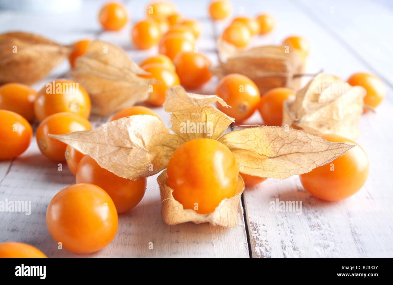 Frische winter Kirschen, Kap Stachelbeeren, peruanische Frucht auf hölzernen weißen Schreibtisch. gesunder Lebensstil Stockfoto