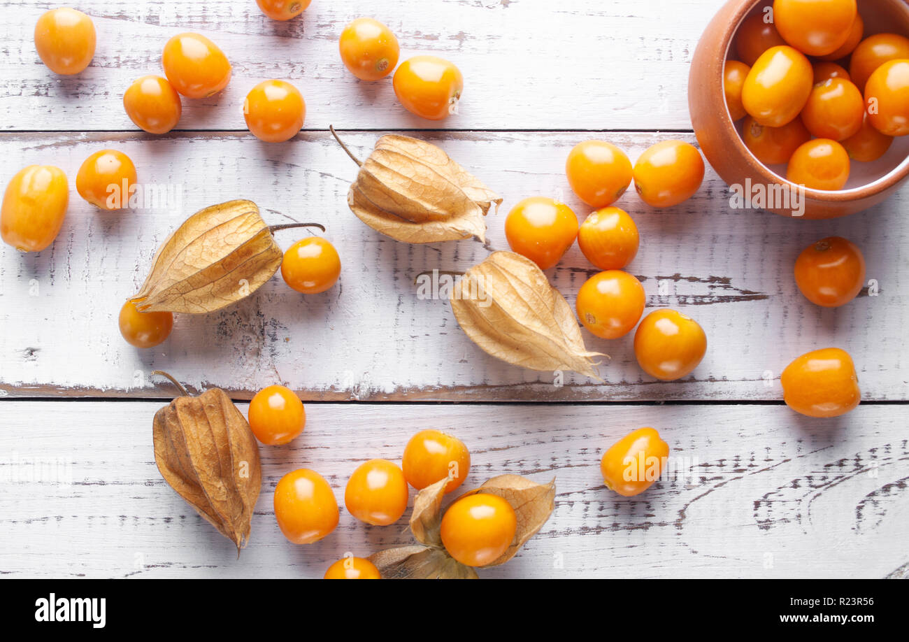 Frische winter Kirschen, Kap Stachelbeeren, peruanische Frucht auf hölzernen weißen Schreibtisch. gesunder Lebensstil Stockfoto