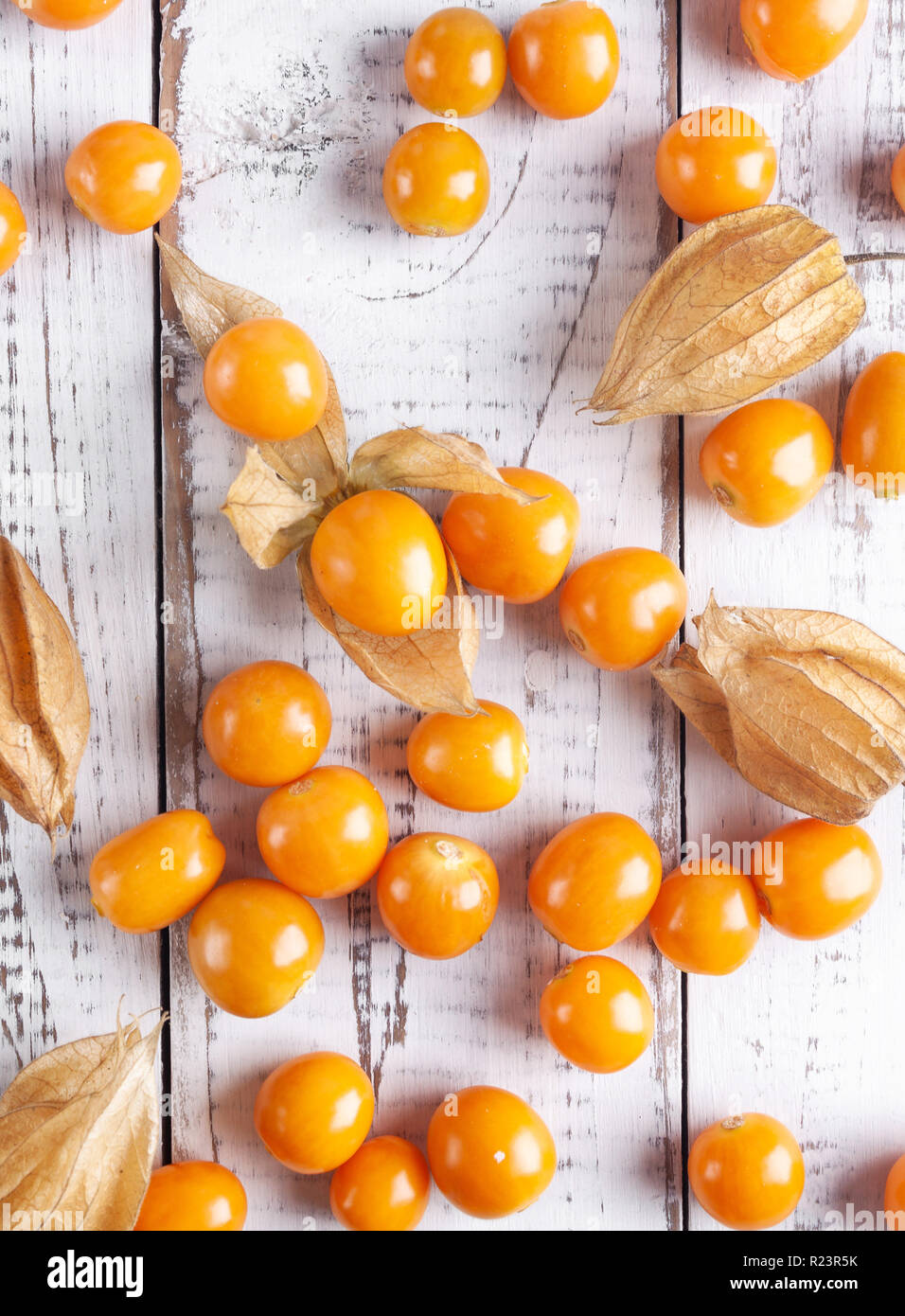 Frische winter Kirschen, Kap Stachelbeeren, peruanische Frucht auf hölzernen weißen Schreibtisch. gesunder Lebensstil Stockfoto