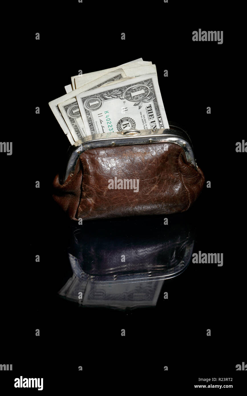 Eine braune Geldbörse mit US-Dollarnoten auf schwarzem Hintergrund. Stockfoto