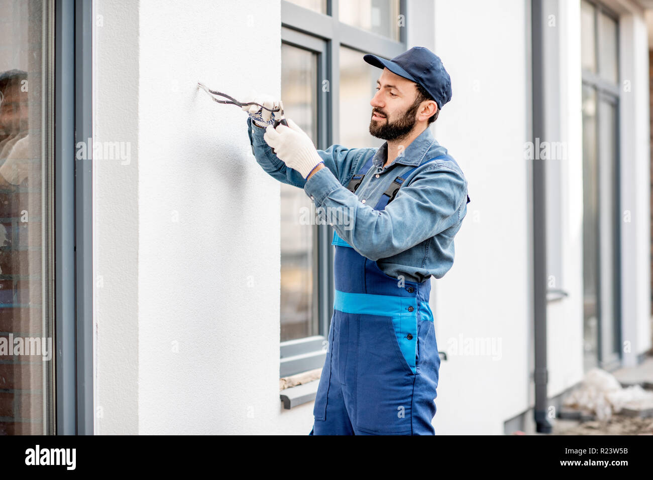 Builder die elektrische Verkabelung an der Fassade für die Außenbeleuchtung Stockfoto