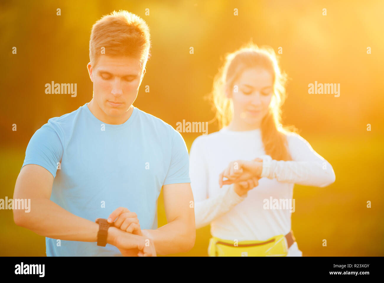 Foto von Paar junge Athleten auf die Uhr im Park im Sommer Tag suchen Stockfoto