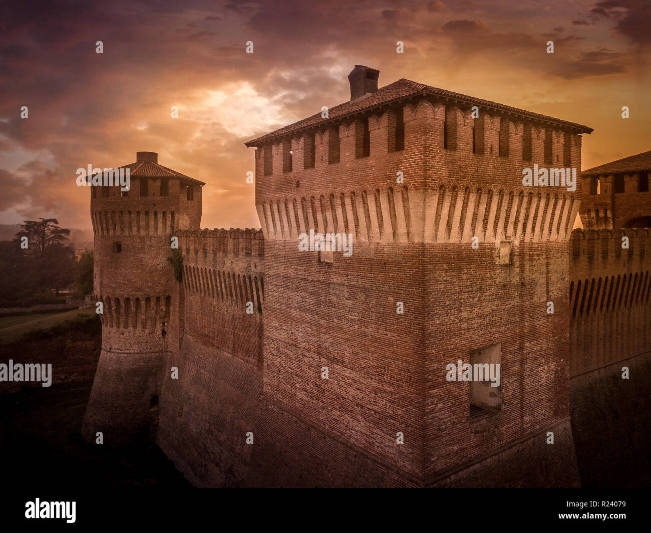 Antenne Sonnenuntergang Blick auf die mittelalterliche Soncino . Schloss aus Backstein in der Region Lombardei in Italien mit dramatischen Himmel Stockfoto