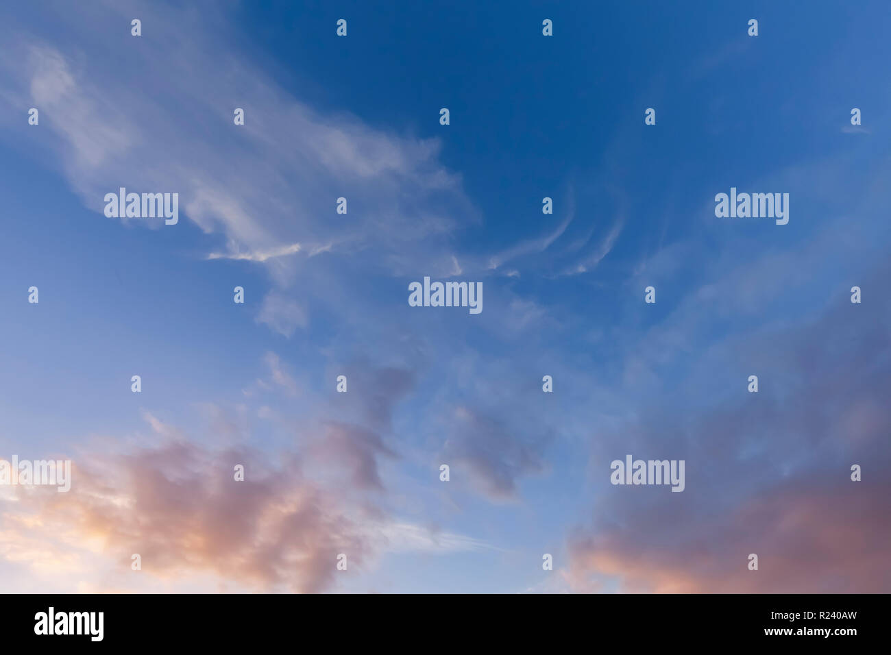 Große wispy Wolken und blauer Himmel. Am frühen Morgen Sonnenlicht mit rosa Farben Stockfoto
