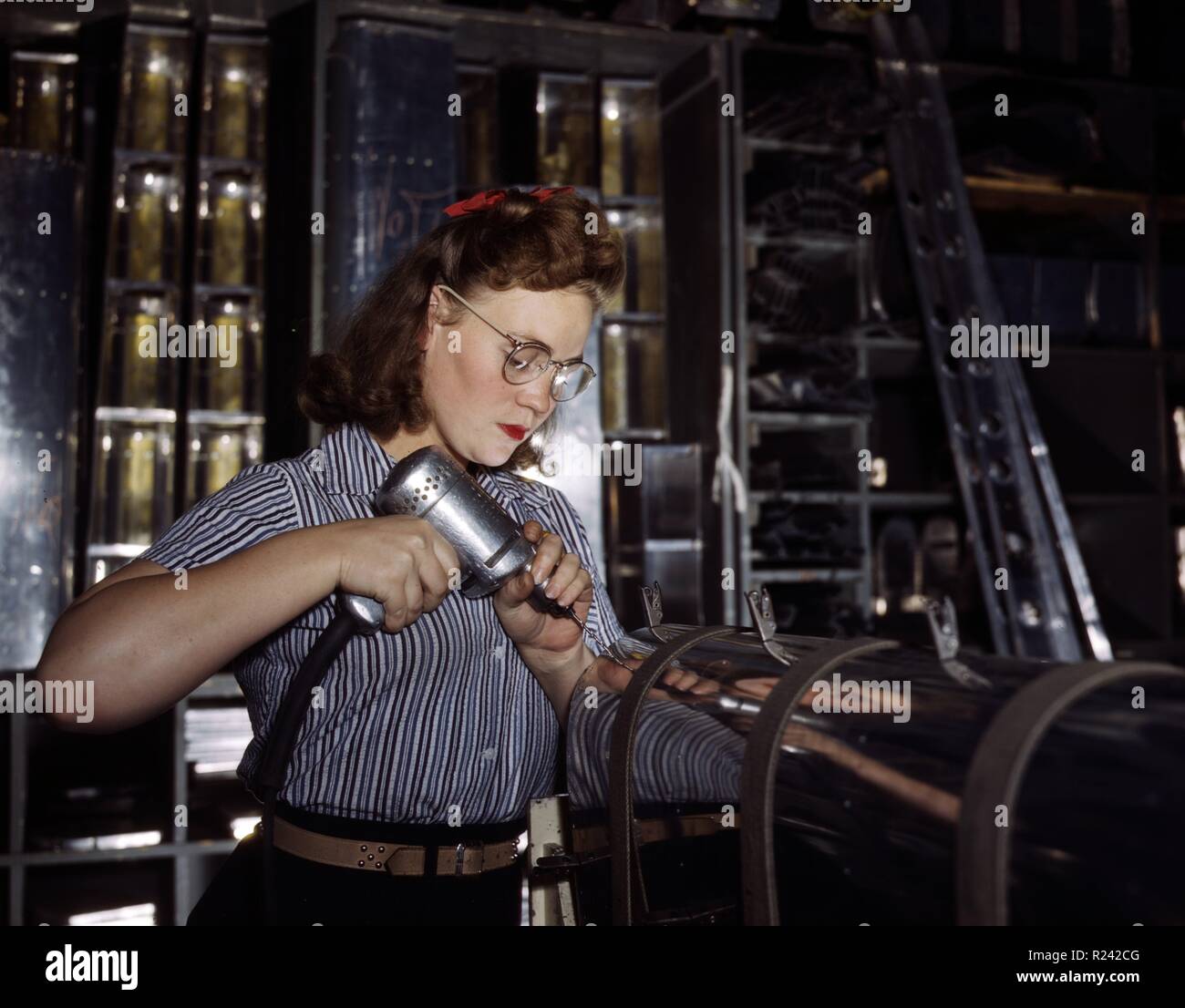 Farbfoto der weiblichen Angestellter eine Handbohrmaschine auf der North American Aviation Inc. fotografiert von Alfred T. Palmer in Betrieb. Vom 1942 Stockfoto