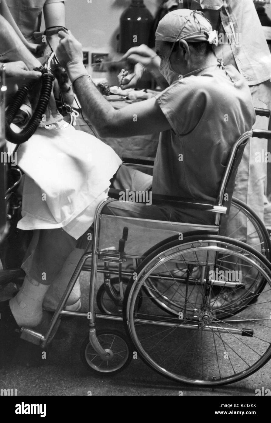 US-amerikanischer Chirurg Henry Swan II (1913 – 1996) Henry Swan darstellende Chirurgie vom Rollstuhl 1960. Swan Pionier im Einsatz von Hypothermie (Kühlung Patienten auf eine sehr niedrige Körpertemperatur), um den ersten Operationen am offenen Herzen zu ermöglichen. Zwischen 1953 und 1963 Stockfoto