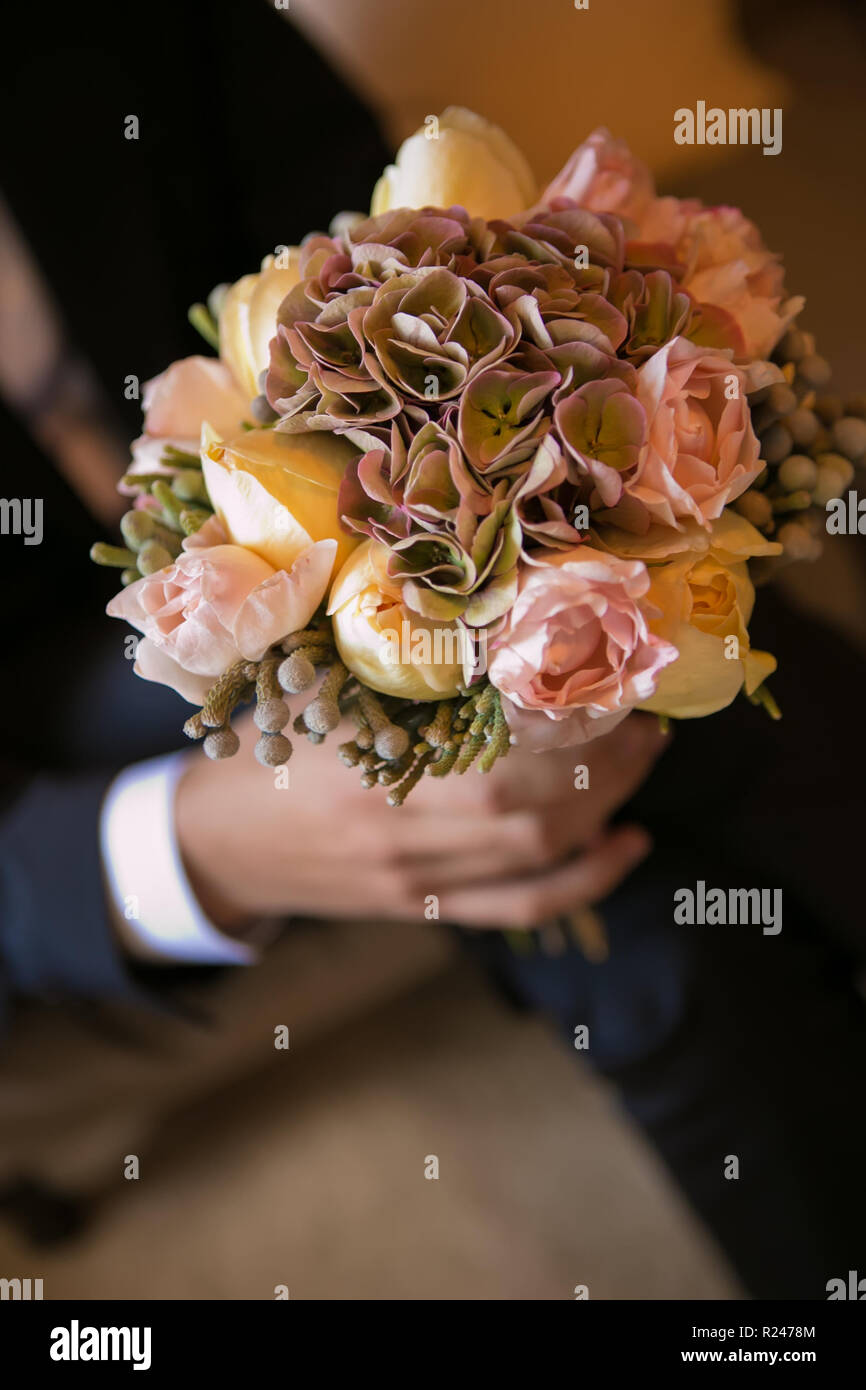 Bräutigam Holding in die Hände zarte, teuer, trendy Braut Hochzeit Blumenstrauß. Stockfoto