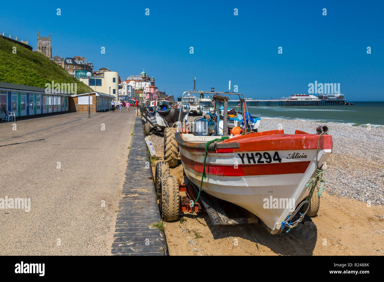 Blick auf Cromer Pier und Boote am Strand an einem Sommertag, Cromer, Norfolk, England, Vereinigtes Königreich, Europa Stockfoto