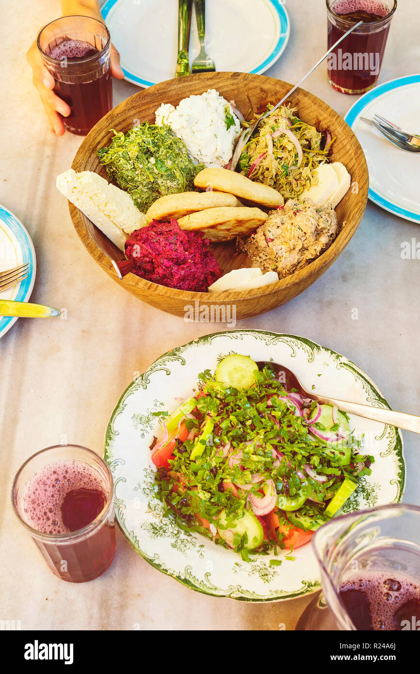 Georgische Küche. close-up Gemüse Salat, Mais Brot, Käse in Houten und frischen natürlichen Saft, Ansicht von oben Stockfoto