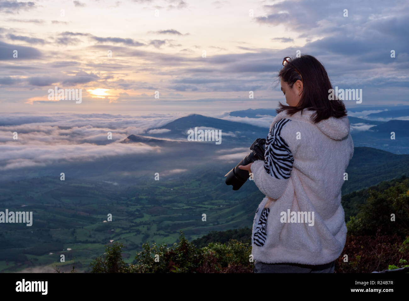 Frau touristische betrachten die Kamera nach einem Foto auf Natur Landschaft der Sonne, Nebel und die Berge nehmen während der Sunrise Hintergrund auf Phu Ruea Stockfoto