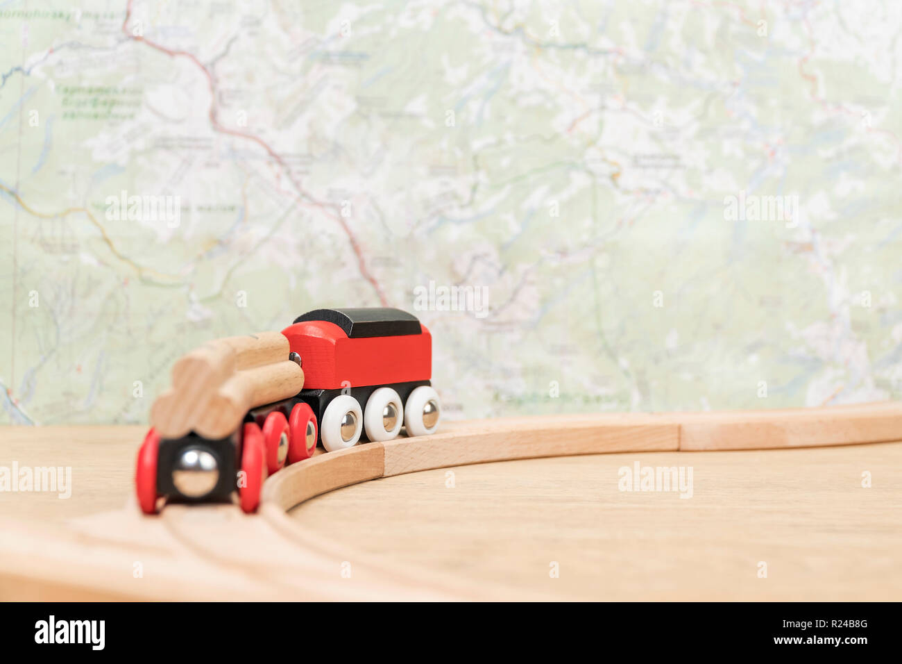 Kinder Spielzeug Holz- Zug an der Gabelung nach rechts in Richtung der Karte auf einem unscharfen Hintergrund Stockfoto