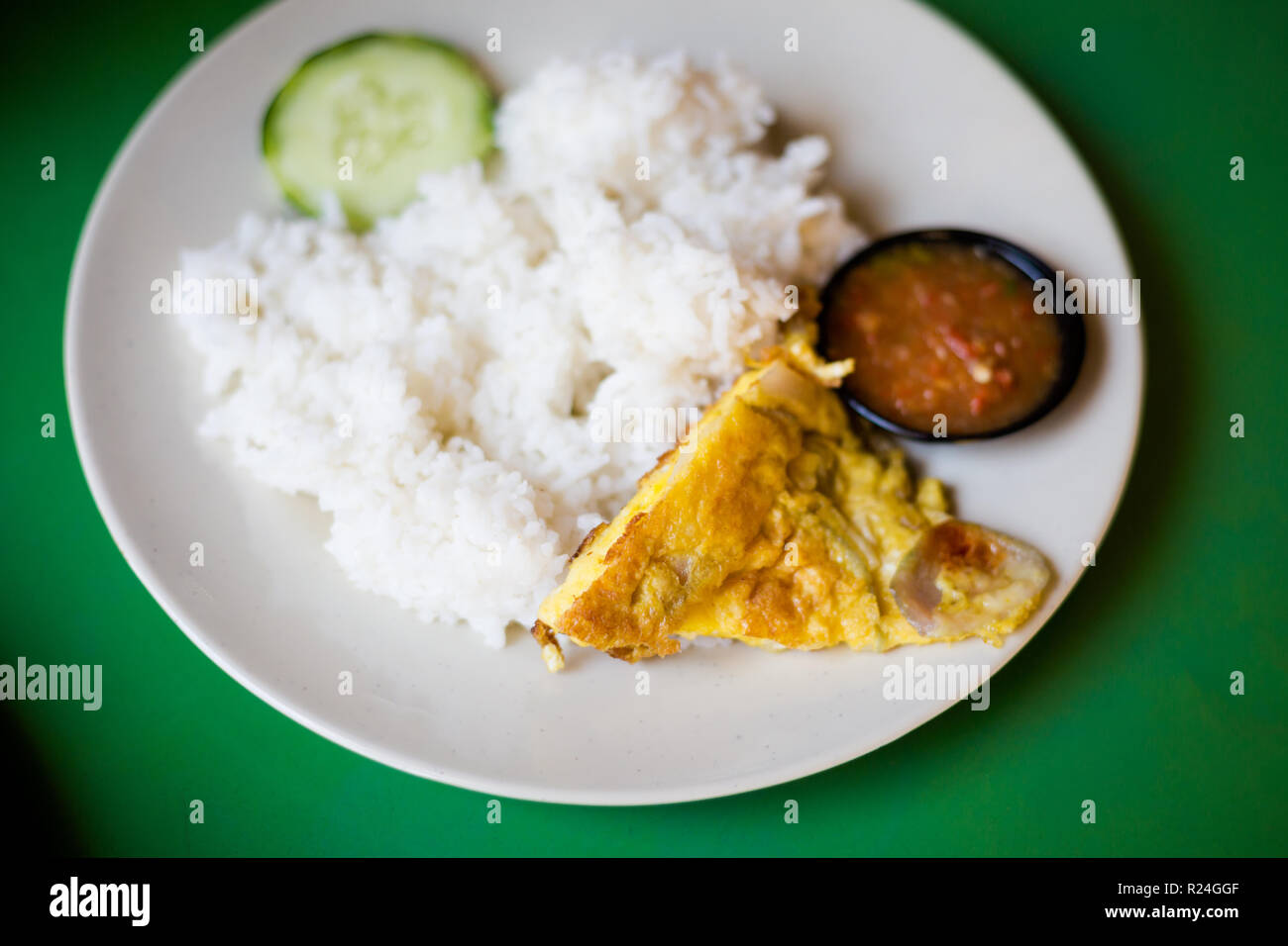 Frisch zubereitet malaysischen ei Omelette auf Reis mit Gurke und Sambal in einem lokalen Restaurant in Malakka. Traditionelle asiatische Küche aus frischen Zutaten Stockfoto