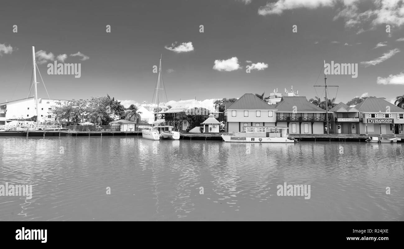 St. Johns, Antigua - März 05, 2016: Kai mit Häuser und Yachten im türkisblauen Meer auf blauen Himmel. Reisen und Fernweh. Sommer Urlaub auf der tropischen Insel. Stockfoto