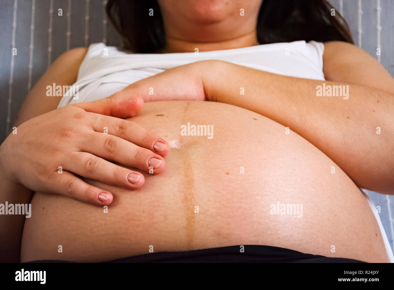 Hände einer schwangeren Frau, Ihren Bauch streicheln. Neues Leben Konzept Stockfoto