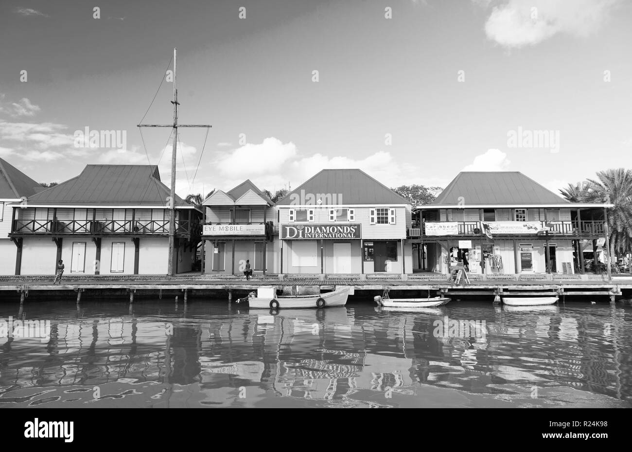 St. Johns, Antigua - März 05, 2016: Boote im Meer im Dorf Kai angedockt an Häusern auf blauen Himmel. Sommer Urlaub auf der tropischen Insel. Entdeckung und Abenteuer. Fernweh. Stockfoto
