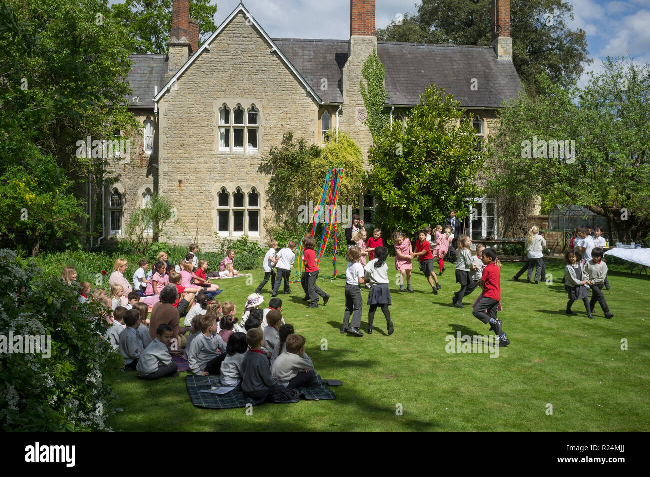 Schüler tanzen im Garten von Dorchester Abbey, Oxfordshire, um die Maypole herum Stockfoto