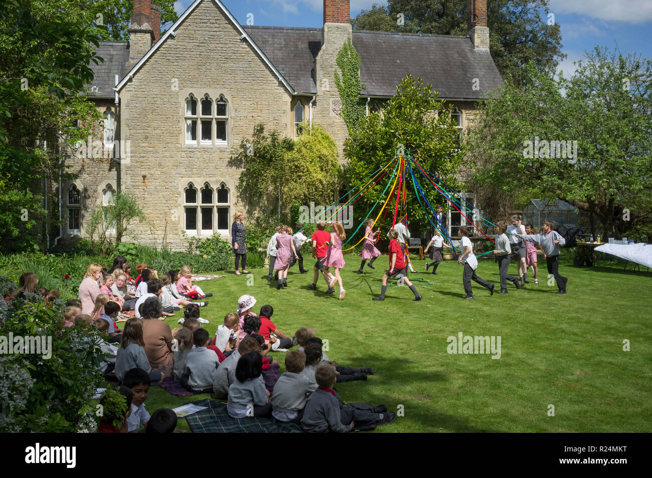 Schüler tanzen im Garten von Dorchester Abbey, Oxfordshire, um die Maypole herum Stockfoto