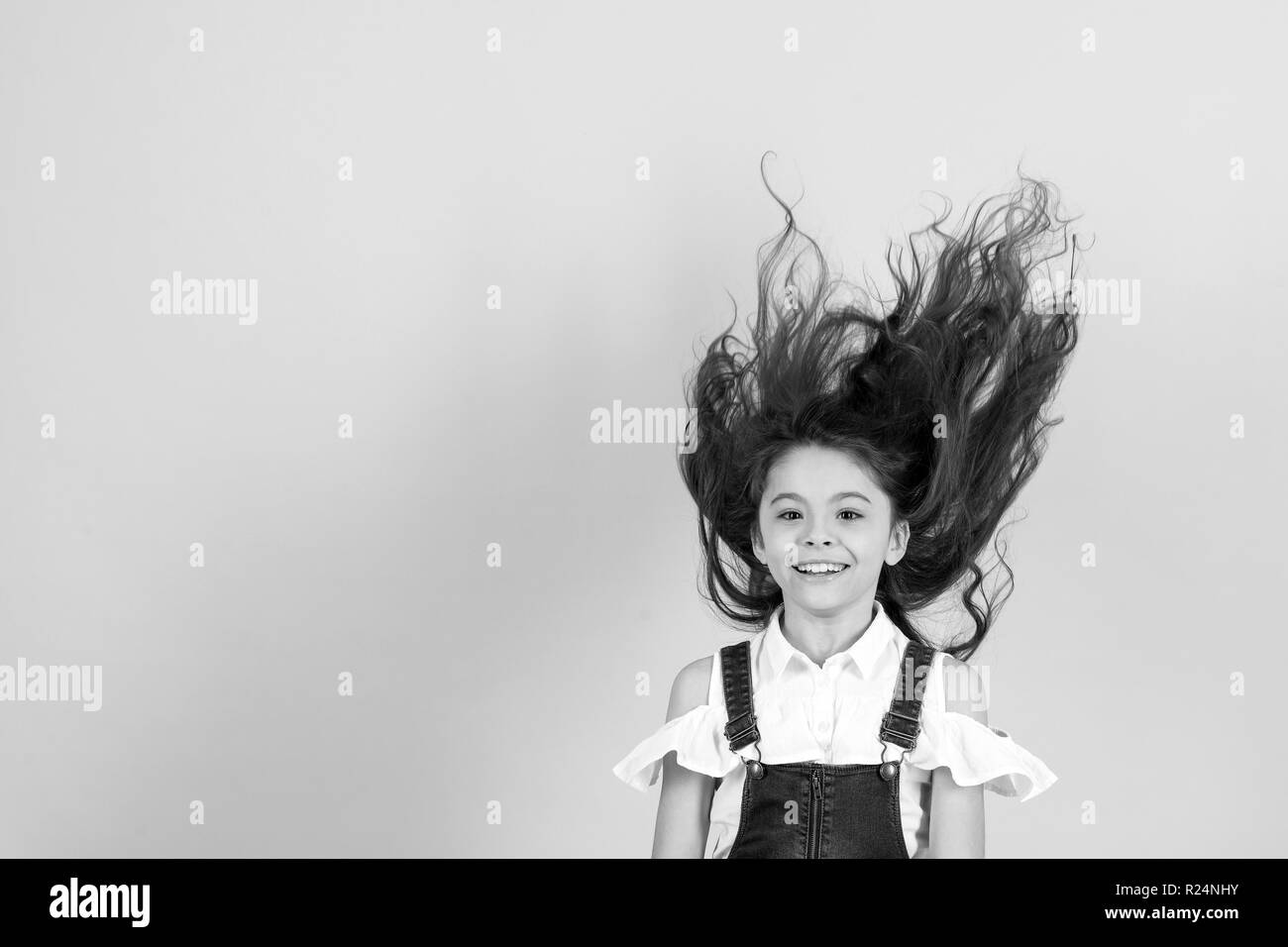 Mädchen mit Haar weht im Wind auf blauem Hintergrund, kopieren Raum Stockfoto