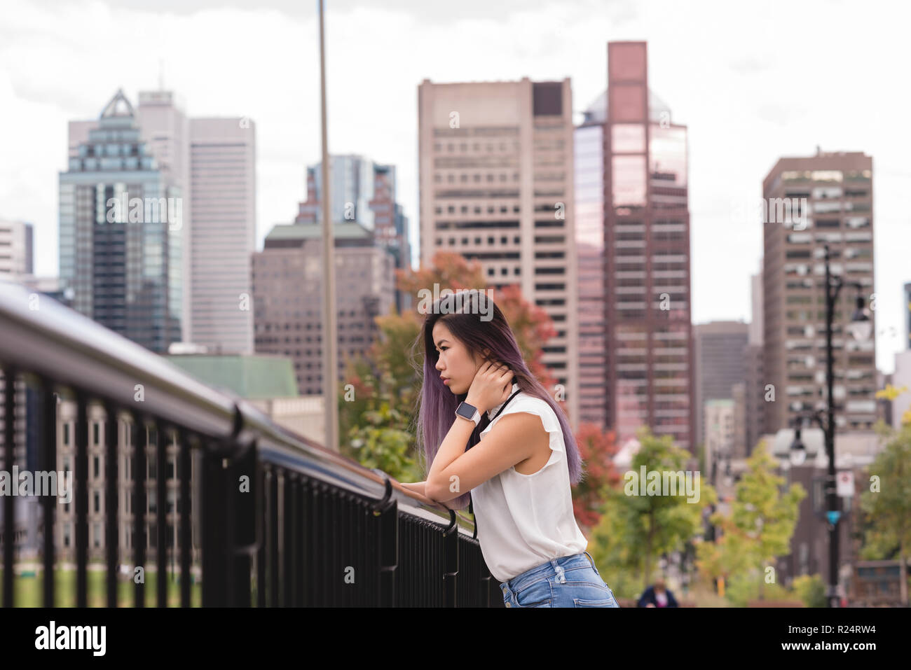 Frau lehnte sich auf Geländer an einem sonnigen Tag Stockfoto