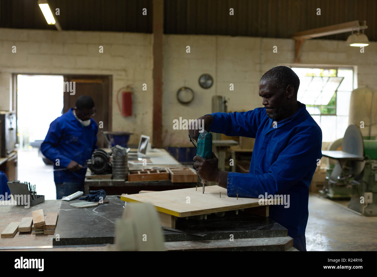 Arbeitnehmer mit der Bohrmaschine Maschine in der Gießerei workshop Stockfoto