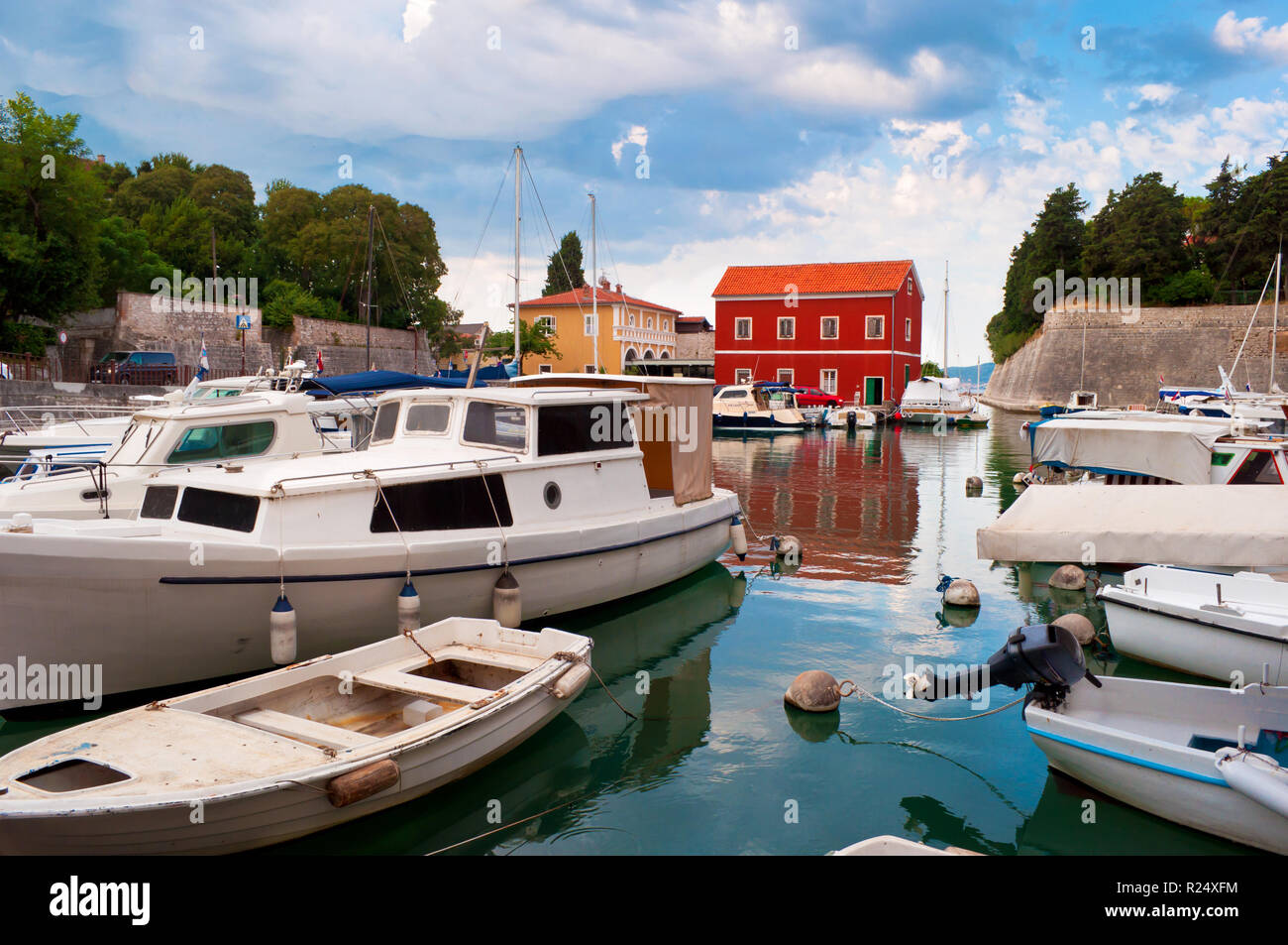 Gemütliche malerische Stadt Zadar, Kroatien. Rot und Orange beherbergt unter grünen Bäumen, in der Nähe des Wassers, wo zahlreiche Boote und Yachten schweben. Dramatische Stockfoto