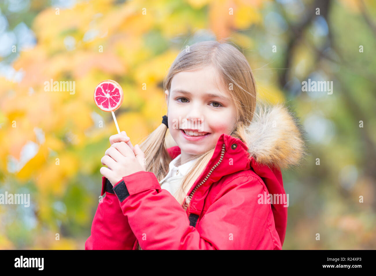 Gerne kleine Mädchen mit Süßigkeiten im Herbst Wald. Nur ein kleines Mädchen. Candy Girl. Glückliche Kindheit. Herbst kam. Stockfoto