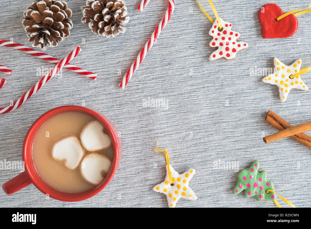 Rot Tasse heißen Kakao mit Rahmen von handgefertigten Weihnachtsschmuck, Zuckerstangen, kiefernzapfen Stockfoto