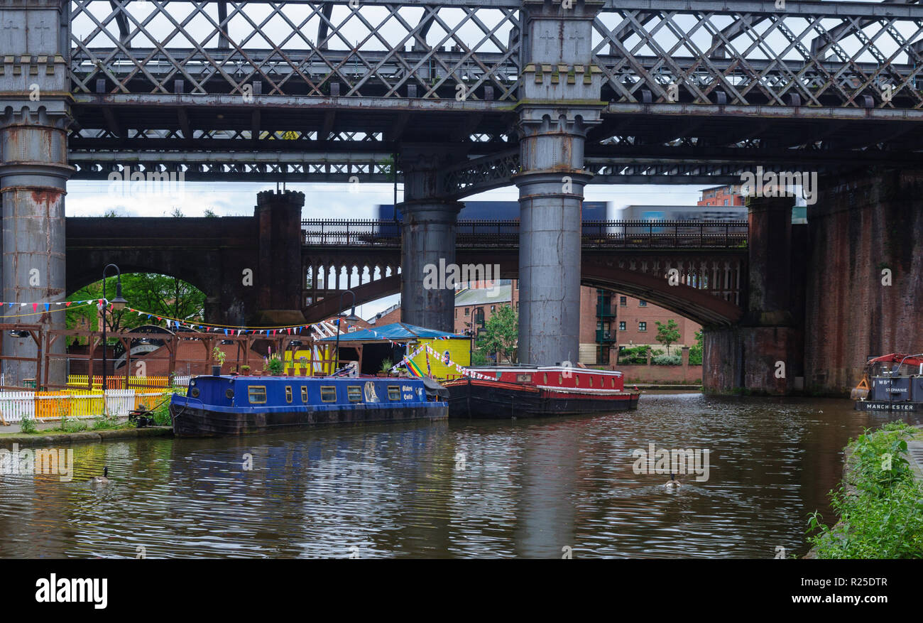 Manchester, England, Großbritannien - 5 Juni, 2012: ein Container Freight Train kreuze Castlefield Becken, wo traditionelle narrowboats auf dem Bridgewat vertäut sind Stockfoto