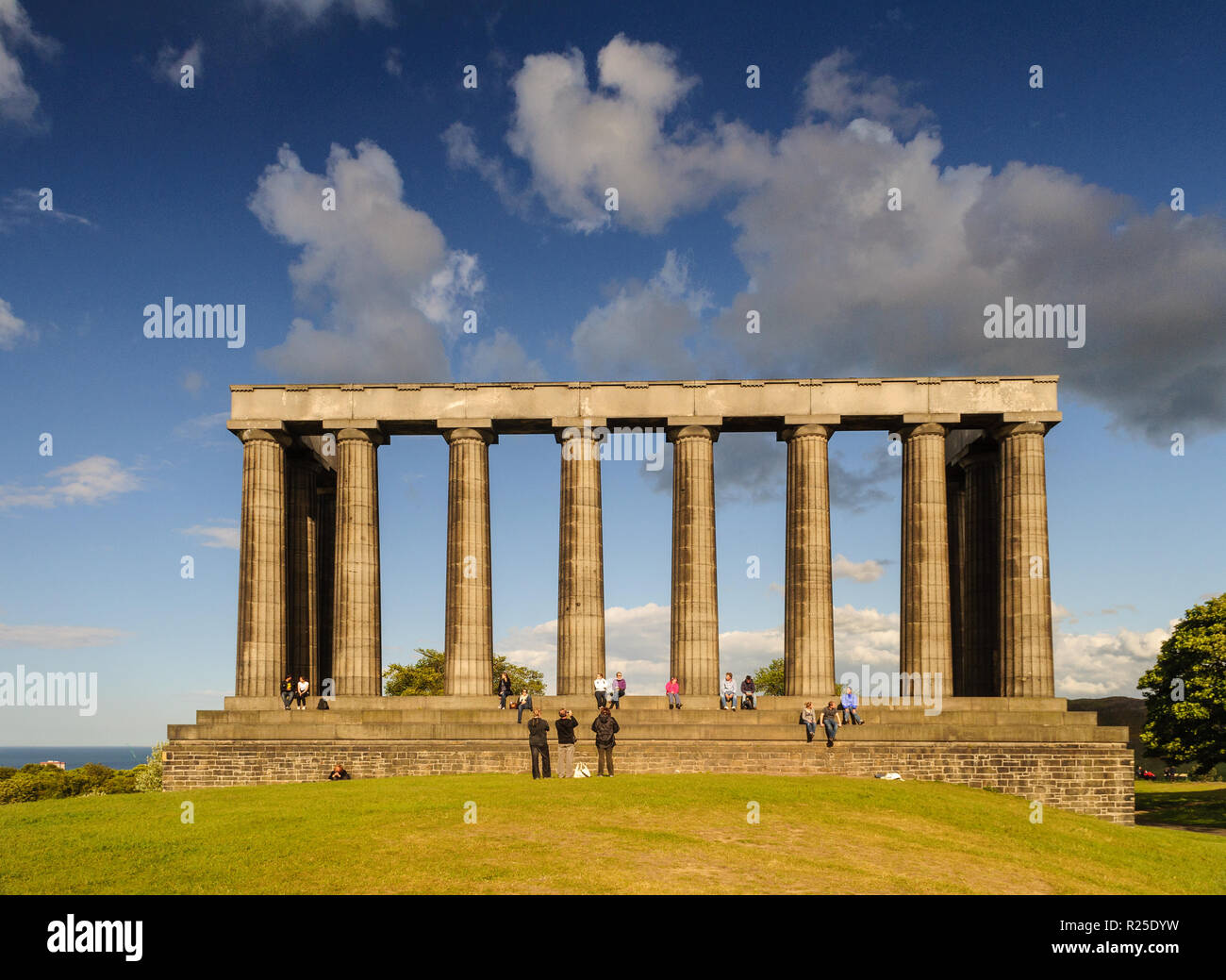 Edinburgh, Schottland, Großbritannien - 30 Mai 2011: Menschen sitzen in der Sonne auf dem verlassenen National Monument von Schottland auf dem Calton Hill, Edinburgh. Stockfoto