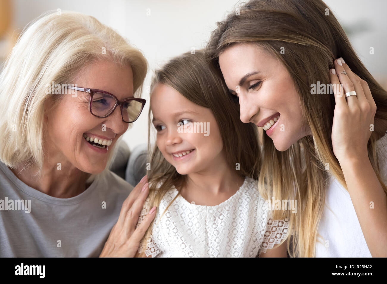 Happy senior Großmutter umarmt kid Enkelin und Tochter Ha Stockfoto