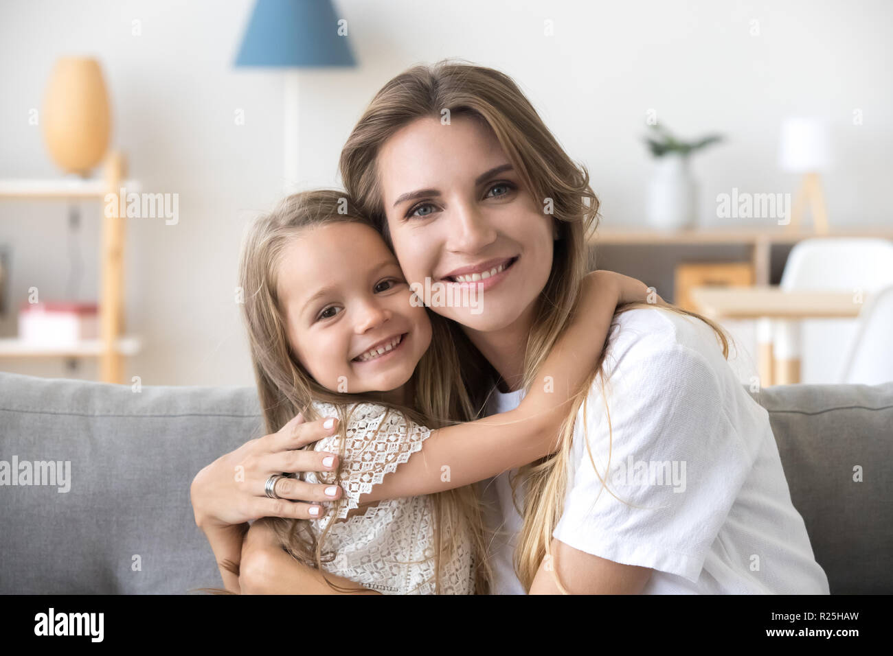 Gerne liebevolle junge Mutter umarmen kleine Tochter im Vorschulalter, por Stockfoto