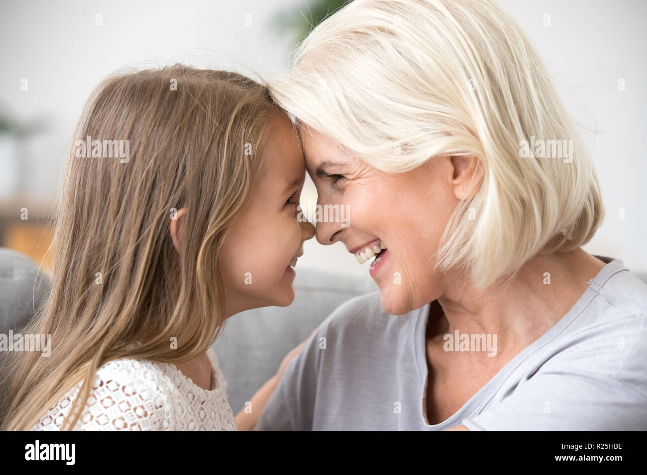 Glücklich im mittleren Alter Oma und Enkelin Nase berühren. Stockfoto