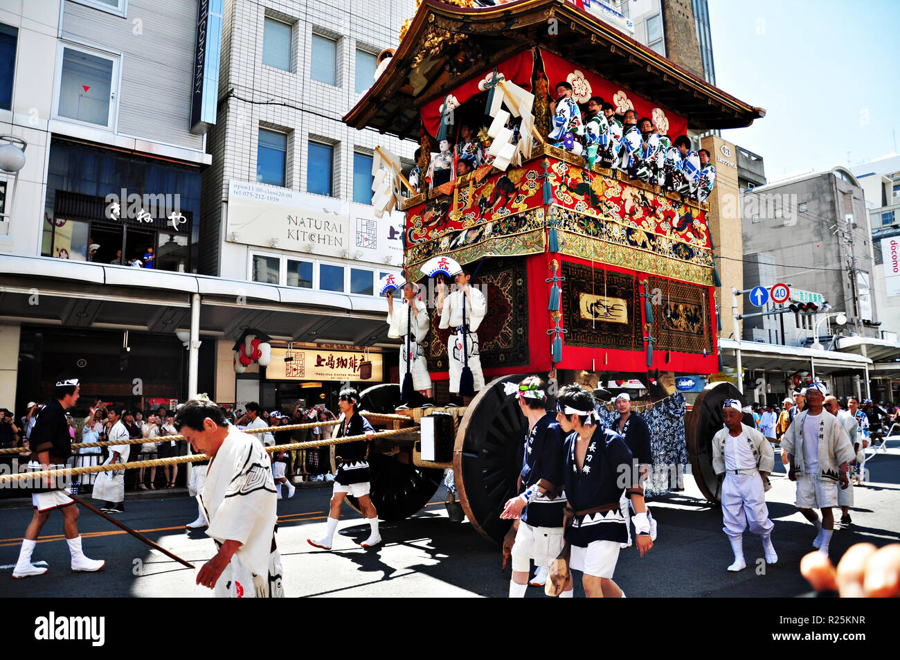 KYOTO, JAPAN: eine hoch dekorierte Schwimmer zusammen mit den sie begleitenden Männer in traditionellen japanischen Kleidung wird in einer Parade während der Gion Ma gezogen Stockfoto