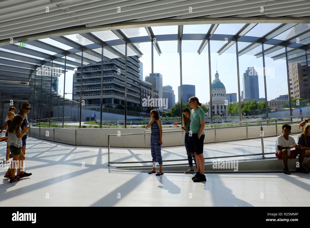 Besucher innerhalb des Gateway Arch Nationalpark mit der Innenstadt von St. Louis im Hintergrund. Stockfoto