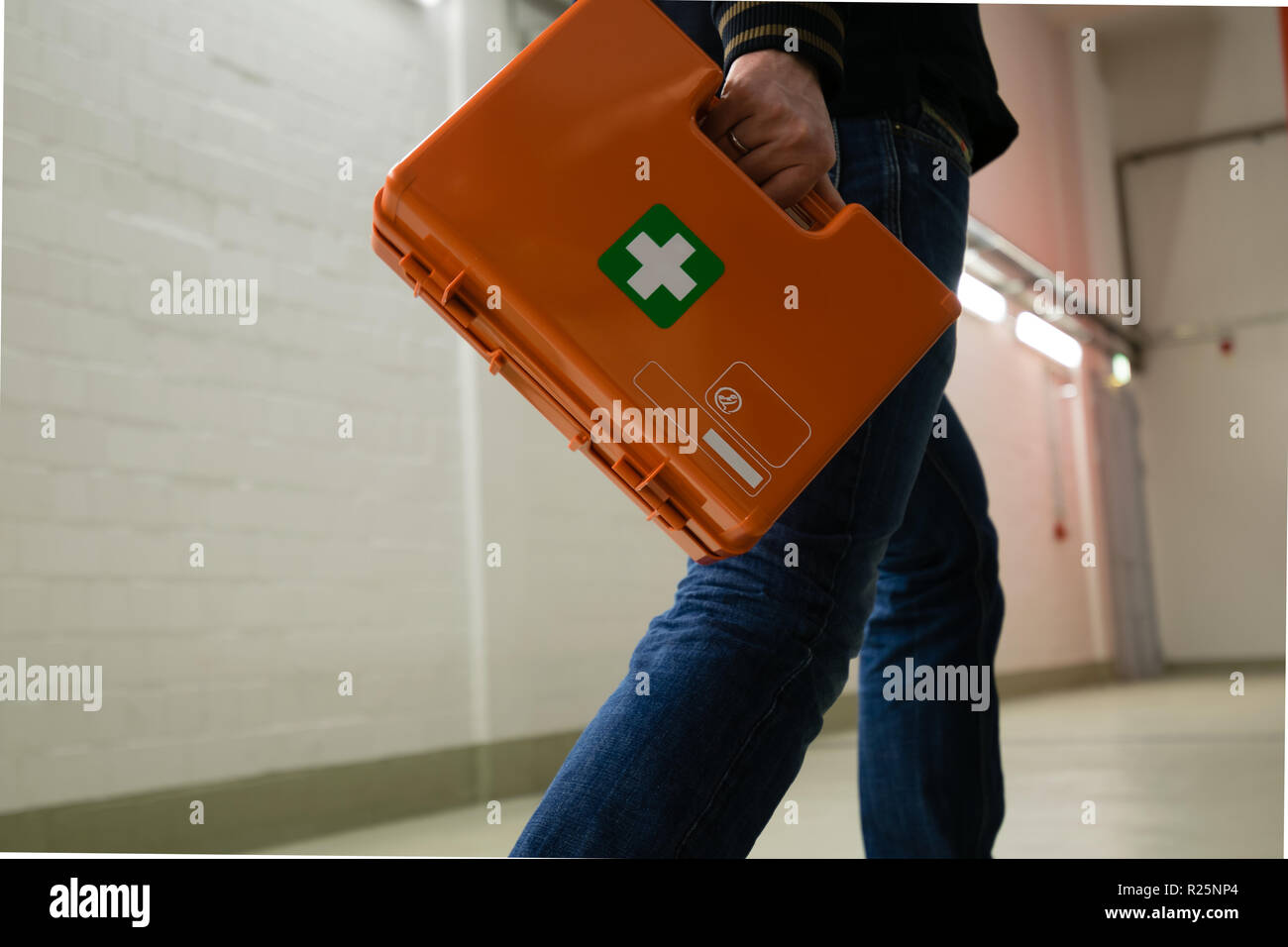 Erstversorgung nach einem Unfall bei der Arbeit. Ersthelfer mit erste-Hilfe-Kit, Deutschland. Stockfoto