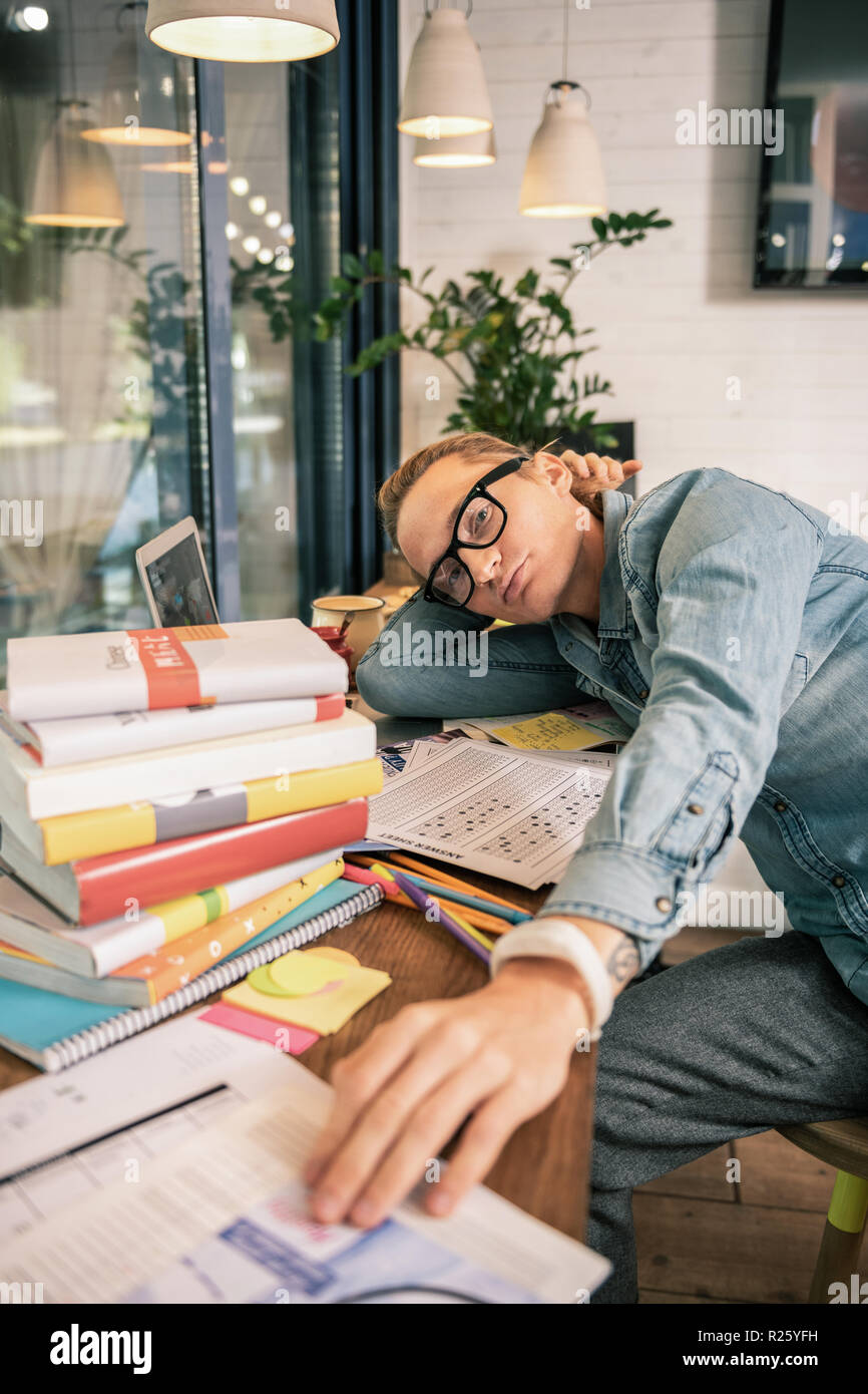 Ernsthaften jungen Studentin von Büchern umgeben Stockfoto