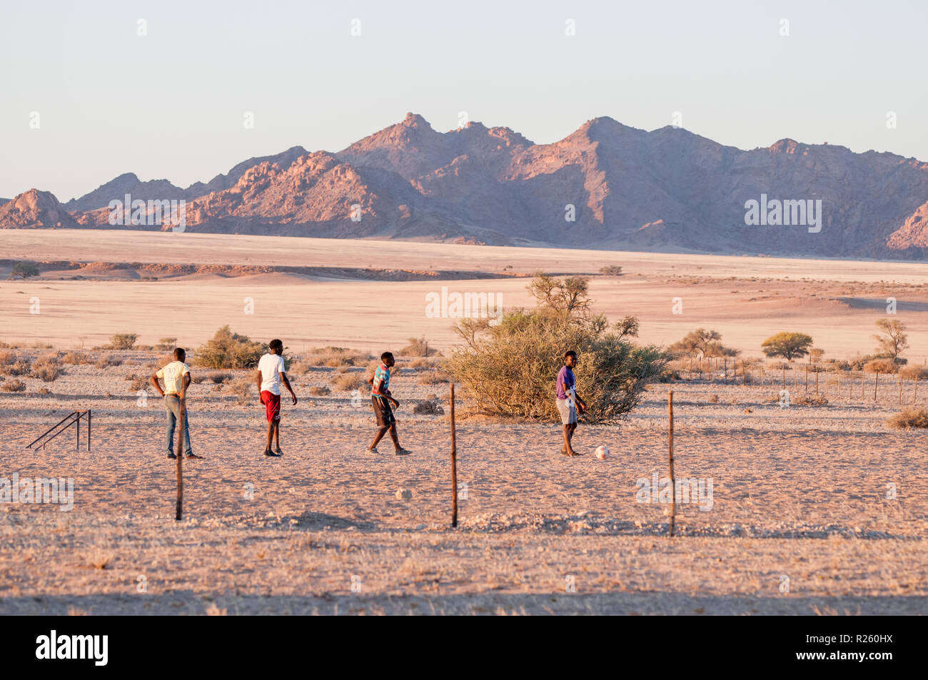 4 junge Jungen Fußball spielen in der Namib Wüste, Sossus Oasis Campingplatz, Namibia Stockfoto
