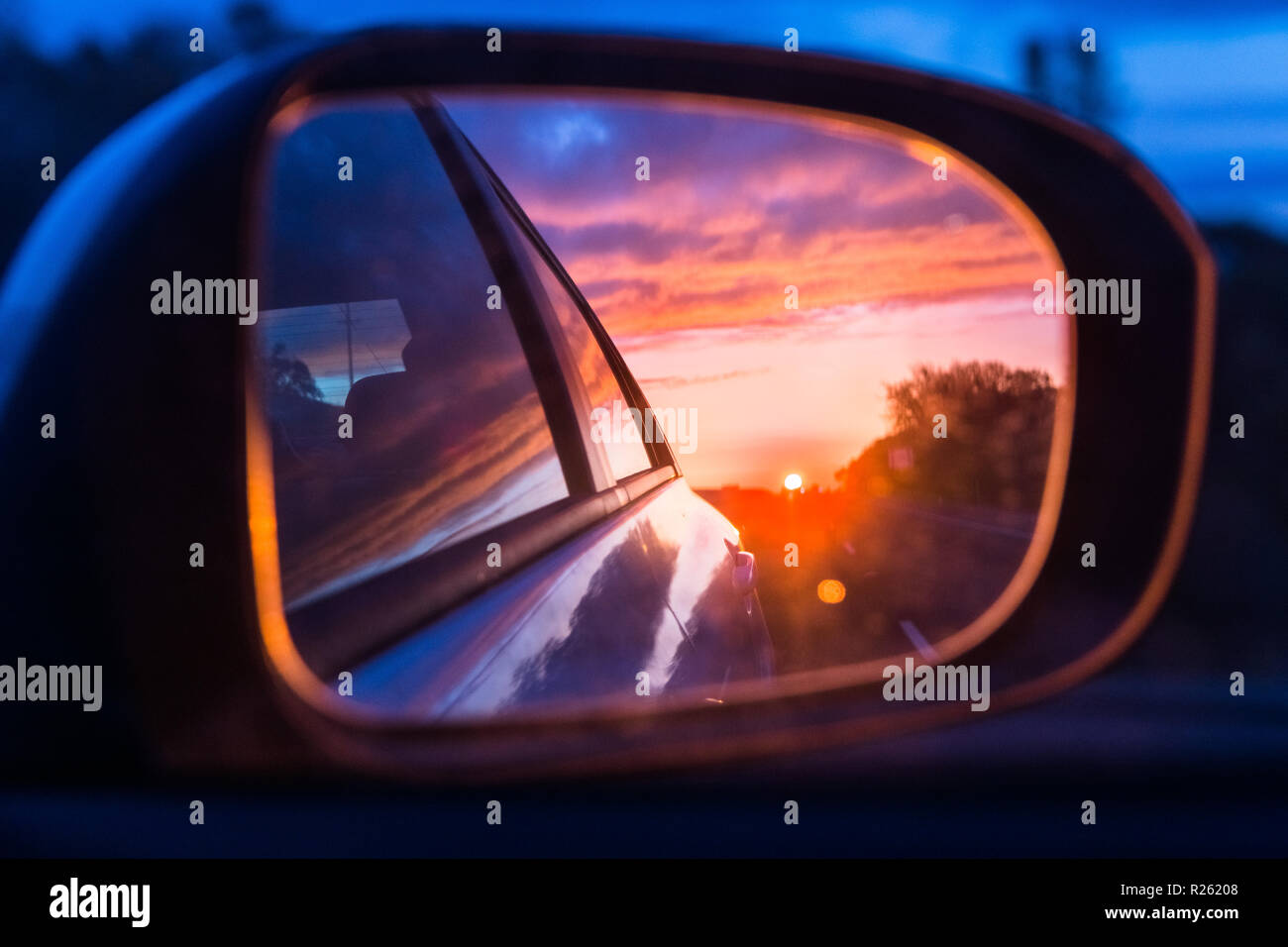 Feurigen Sonnenuntergang am Außenspiegel des Autos gesehen Stockfoto