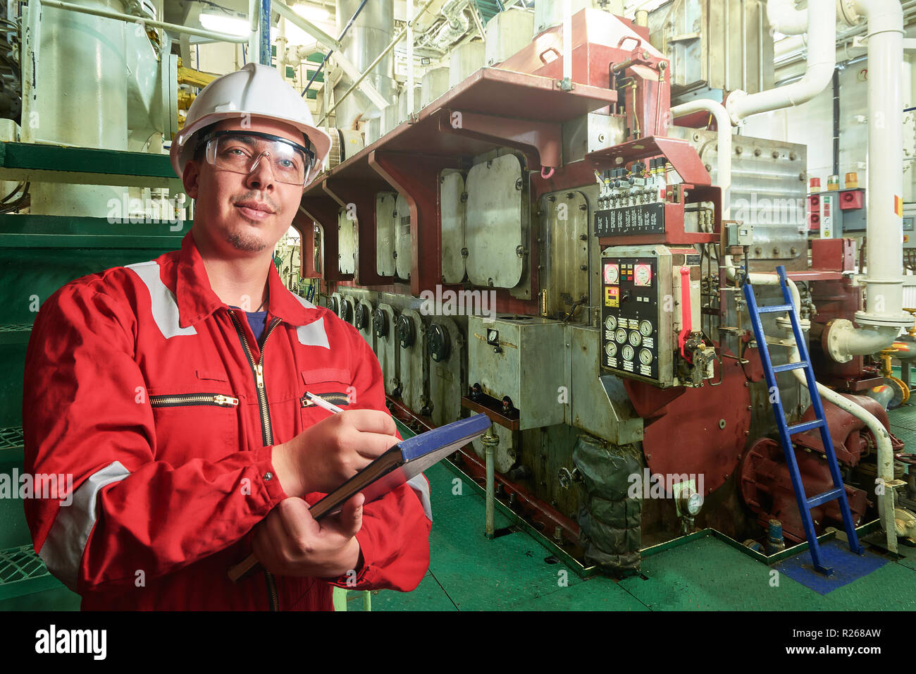 Das Schiff ist Mechaniker in der Nähe der Marine Diesel Generatoren auf ein Handelsschiff in den Maschinenraum mit alle Rohrleitungen, Generatoren, turbins, etc. Etwas schreiben d Stockfoto