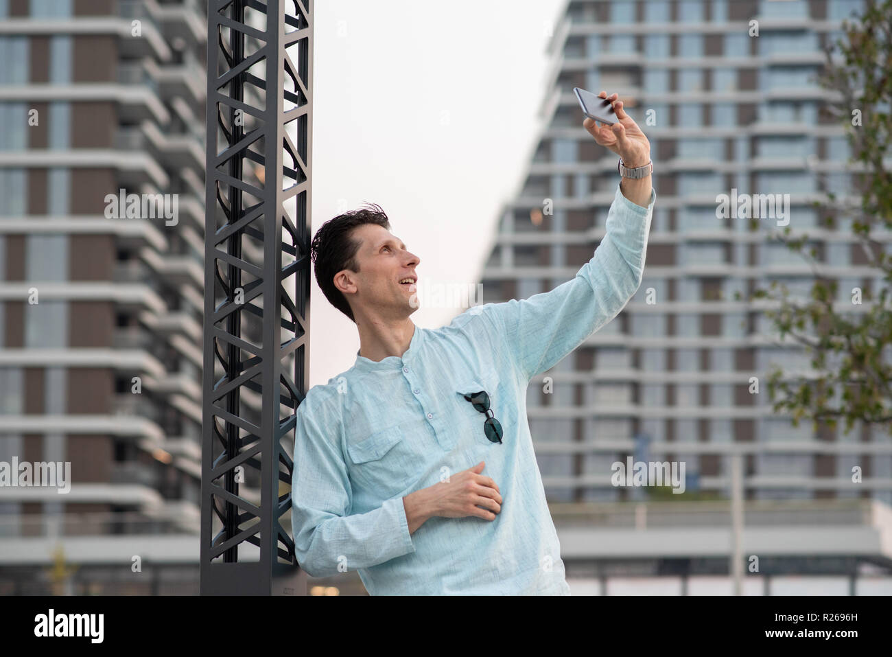 Schöner Mann unter selfie mit seinem Handy vor modernes Gebäude Stockfoto