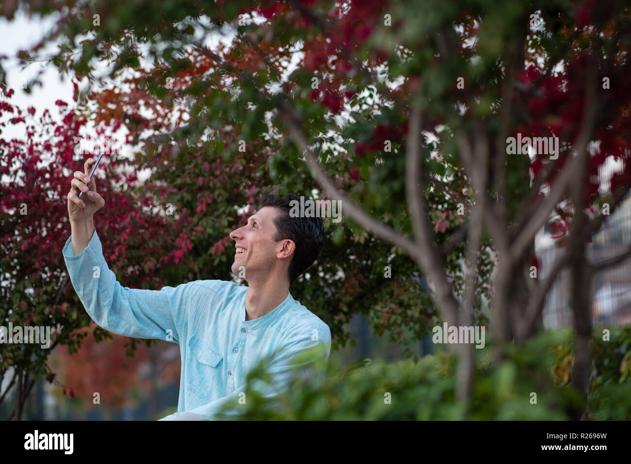 Fröhlicher Mann unter selfie mit seinem Handy in einem Park Stockfoto