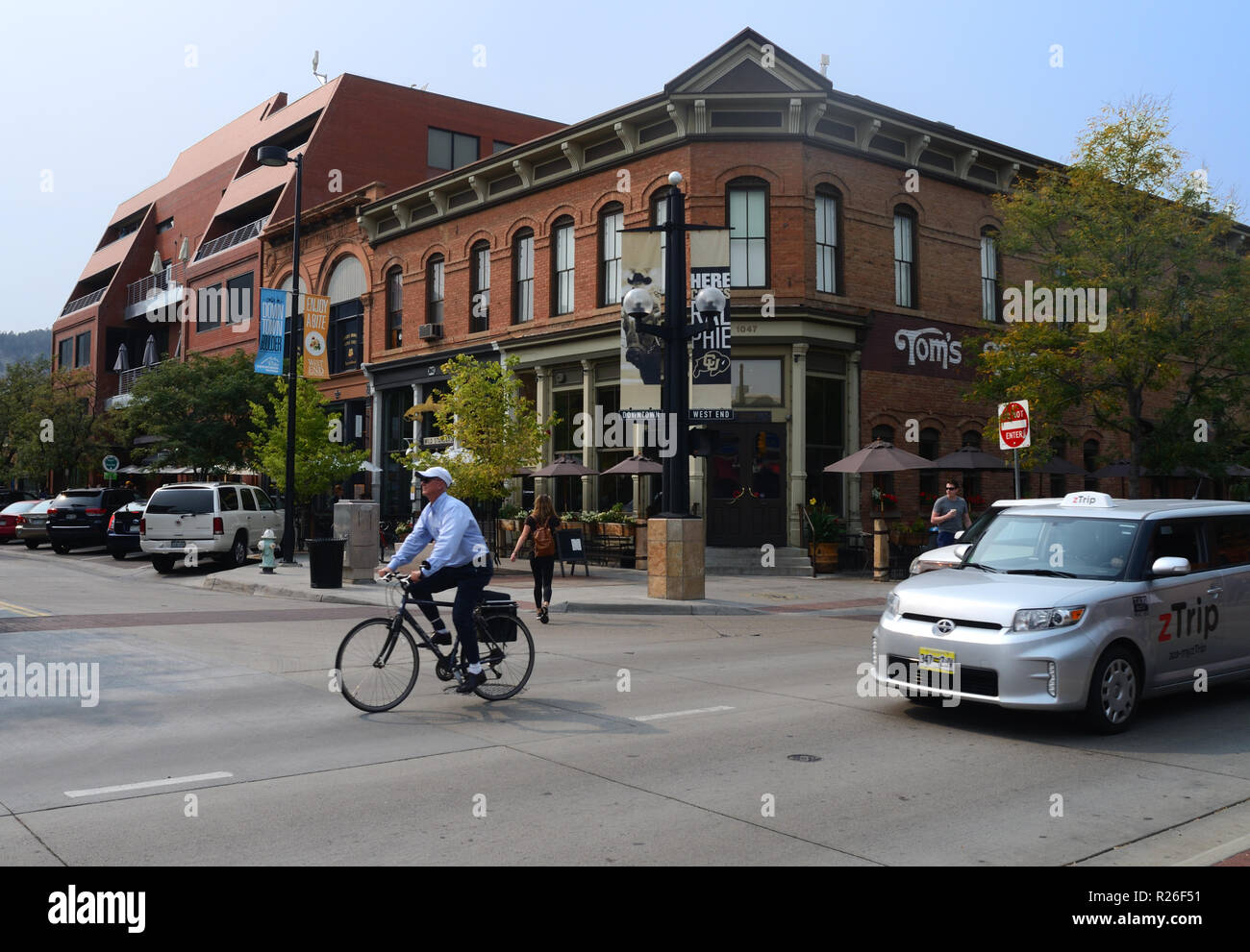 Einen Radfahrer, Automobile und ein Fußgänger auf 10th Street am östlichen Ende der Pearl Street Mall in Boulder, CO. zTrip ist ein Taxiunternehmen in Boulder. Stockfoto