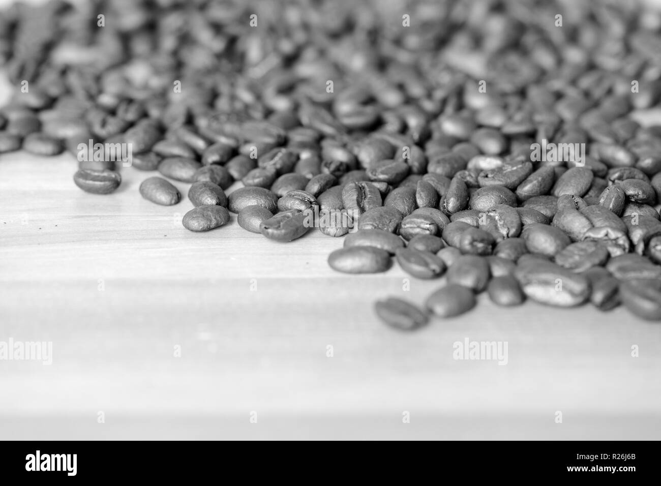 Geröstete Kaffeebohnen auf einer hölzernen Hintergrund. Schwarz und Weiß Stockfoto