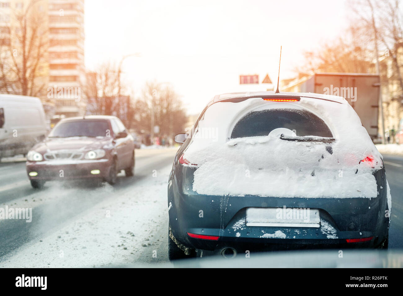 Autos bewegen auf city street auf rutschigen verschneite Straße im Winter. Fahrzeuge mit Schnee bedeckt Drift nach Schneefällen und Blizzard auf der kalten Winter. Weat Stockfoto